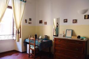 ローマにあるTrastevere Dream Houseのテーブル、ドレッサー、窓が備わる客室です。