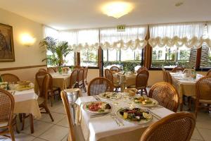 a restaurant with tables and chairs with plates of food at Hotel Eden in Sorrento