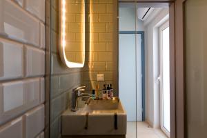 a bathroom with a sink and a mirror at LOC HOSPITALITY Urban Suites in Corfu Town +47 photos