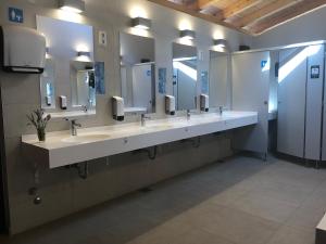 a public bathroom with three sinks and mirrors at Camping Vransko jezero - Crkvine in Pakoštane