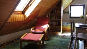 a attic room with two chairs and a window at Helle Ferienwohnung im Loft-Charakter in Essen
