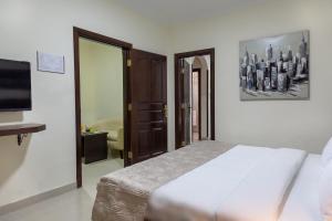 um quarto com uma cama e uma televisão de ecrã plano em 360 Hotel By FHM em Amã