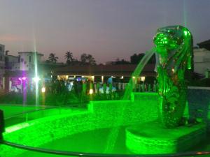 a green fountain in a park at night at Hotel Merlin International in Trichūr
