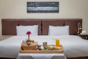 taca z jedzeniem na łóżku z tacą z jedzeniem w obiekcie 360 Hotel By FHM w mieście Amman