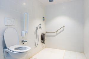 bagno con servizi igienici e telefono appeso al muro di ONOMO Hotel Conakry a Conakry