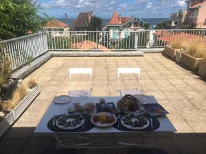 a table with plates of food on a patio at La Rose des Sables - Proche plage & centre-ville in Arcachon