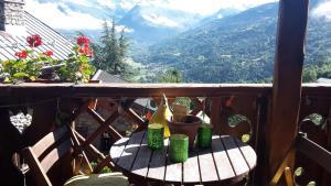 a table on a balcony with a view of mountains at La Portette Chambres d'Hôtes in Bellentre