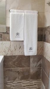 twee handdoeken hangen aan een muur in een badkamer bij Jorela Family Hotel in Ruse