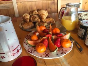 una mesa cubierta con una bandeja de fruta y bollería en La Portette Chambres d'Hôtes, en Bellentre