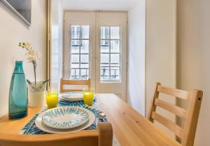 - une table à manger avec deux assiettes et du jus d'orange dans l'établissement Guest Inn Alfama, Premium Apartments, à Lisbonne