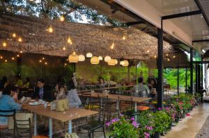 a group of people sitting at tables in a restaurant at At Ruam Chok Hotel in Chiang Mai