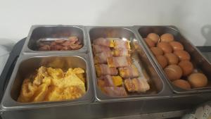 3 plateaux de petit-déjeuner avec des œufs et du bacon dans l'établissement Hotel Joy, à Castel Volturno