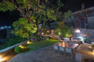 a backyard at night with a table and chairs at 5 Senses in Dikoryfo