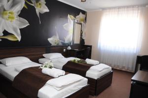 two beds in a room with flowers on the wall at Green Hotel Budapest in Budapest