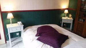 a bed with two pillows on it with two night stands at Jodelle in La Riche