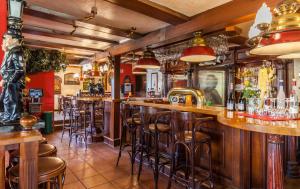 a bar with wooden bar stools in a restaurant at Gasthaus & Pension "Zur Schaabe" in Glowe