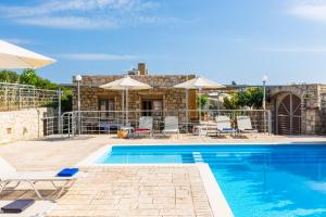 - une piscine avec des chaises et des parasols à côté d'une maison dans l'établissement Villa Evgoron, à Zourídhion