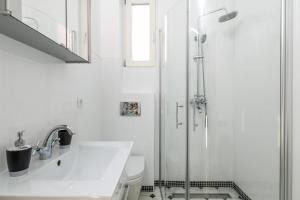 une salle de bain blanche avec une douche et un lavabo dans l'établissement Kantrida Home, à Rijeka 19 autres photos