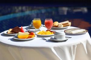 - une table avec des assiettes de nourriture et de boissons dans l'établissement Hotel Pousada São Francisco, à Olinda