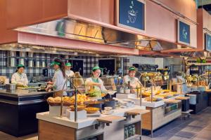 a group of people in a kitchen preparing food at Hotel Bellinzona Sud Swiss Quality in Monte Carasso