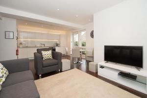 a living room with a couch and a flat screen tv at The Windsor - by Harrogate Serviced Apartments in Harrogate