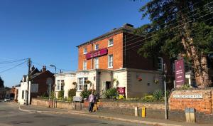 un hombre parado frente a un edificio de ladrillo en The Pytchley Inn en West Haddon