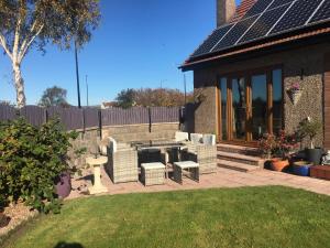 een patio met een picknicktafel en stoelen in een tuin bij Greenbank Bed & Breakfast in Montrose