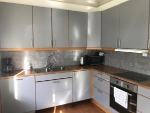 a kitchen with white cabinets and a sink at Guesthouse- Møllegata 39 in Stavanger