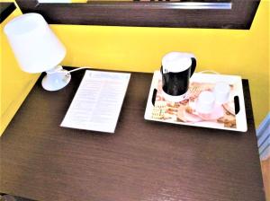 una scrivania con una lampada e un piatto di cibo sopra di Mini Hotel a Genova