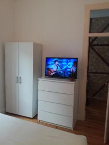 een slaapkamer met een flatscreen-tv op een dressoir bij Flor Liz in Lissabon
