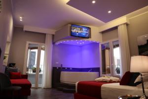 MILLINA SUITES IN NAVONA في روما: غرفة نوم بسرير وتلفزيون بشاشة مسطحة
