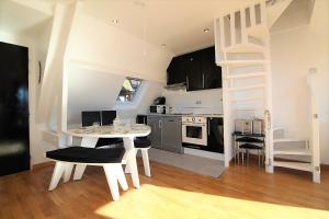 a kitchen with a white table and chairs in a room at CADRE EXCEPTIONNEL: Duplex Classé 4**** Tennis, Piscine, Parking, Linge inclus, WIFI, Matériel BÉBÉ, proximité CENTRE in Deauville