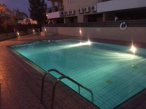 a large swimming pool with green water at night at Hermes Complex 2 Paralimni Cyprus in Paralimni