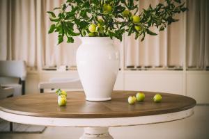 un jarrón sentado sobre una mesa con fruta. en Furnirussi Tenuta, en Carpignano Salentino