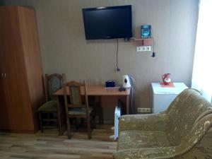 a living room with a table and a television on the wall at Atlant Hotel in Ostroh