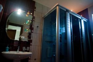 a bathroom with a shower and a sink and a mirror at Hotel Luka's in Berane