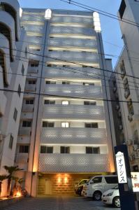 un edificio alto con macchine parcheggiate di fronte di Hotel Chuo Oasis ad Osaka