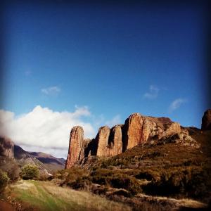 una vista del desierto con rocas altas en el fondo en Casa Barranquero, en Riglos