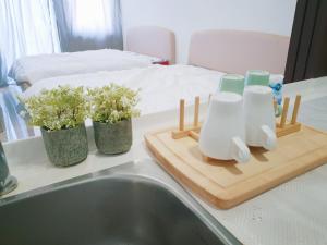 a kitchen counter with two bottles and a cutting board with flowers at Trefoil Setia Alam- Simple No 5- Near Setia City Mall & Convention Centre in Setia Alam