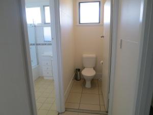 a small bathroom with a toilet and a window at Edge Hill Clean & Green Cairns, 7 Minutes from the Airport, 7 Minutes to Cairns CBD & Reef Fleet Terminal in Cairns +12 photos