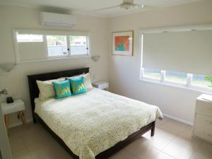 een slaapkamer met een bed en 2 ramen bij Edge Hill Clean & Green Cairns, 7 Minutes from the Airport, 7 Minutes to Cairns CBD & Reef Fleet Terminal in Cairns