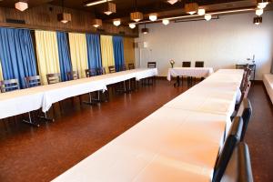 une rangée de tables et de chaises dans une pièce dans l'établissement Hotel Töss, à Winterthour