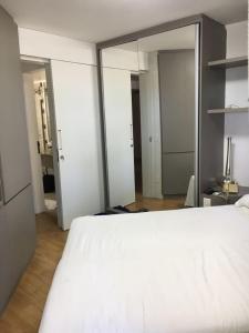 sypialnia z białym łóżkiem i dużym lustrem w obiekcie Flat Jatiúca Suítes Resort w mieście Maceió +11 zdjęć