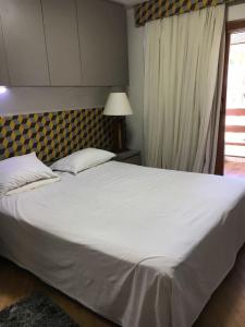 duże białe łóżko w sypialni z oknem w obiekcie Flat Jatiúca Suítes Resort w mieście Maceió