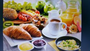 a table with a breakfast of croissants and fruit and juice at Maillas D'en Haut in LʼIsle-en-Dodon
