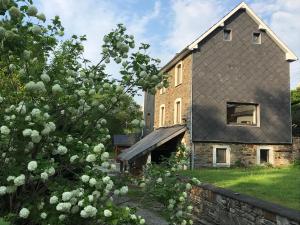 uma casa de tijolos com um telhado preto em LATYKA B&B em Robertville