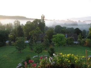 una vista de un jardín con niebla en el fondo en Splendide vue Pyrénées, Rez de jardin 2 chambres, en Montjoie-en-Couserans