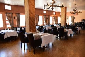 une salle à manger avec des tables, des chaises et un tissu de table blanc dans l'établissement Hotel Töss, à Winterthour