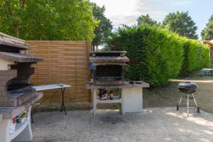 a outdoor grill and smoker in a yard at Camping Les Maraises in Saint-Martin-de-Ré