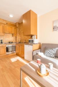 a living room with a couch and a kitchen at Pierre & Vacances Andorra Alba in El Tarter +21 photos
